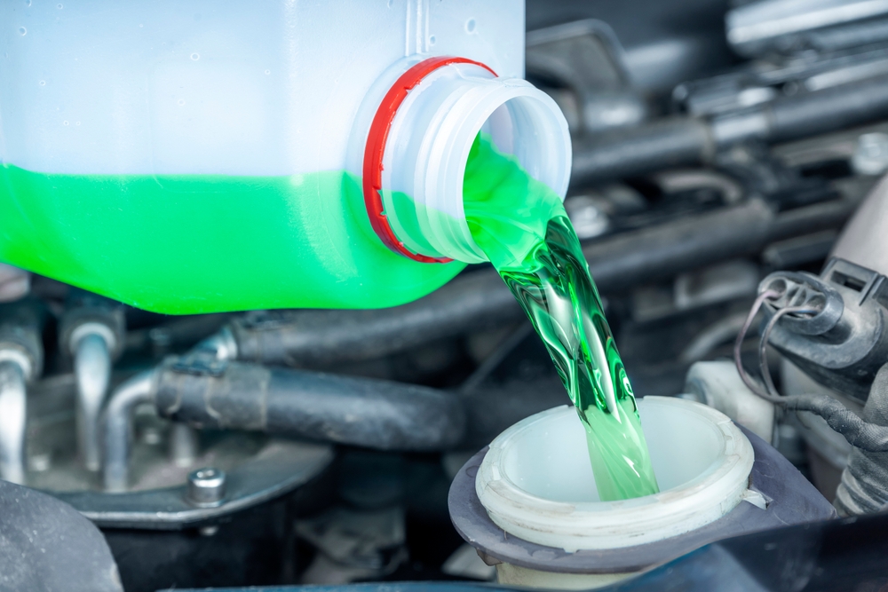 Close Up,of,pouring,green,antifreeze,into,car,coolant,reservoir.