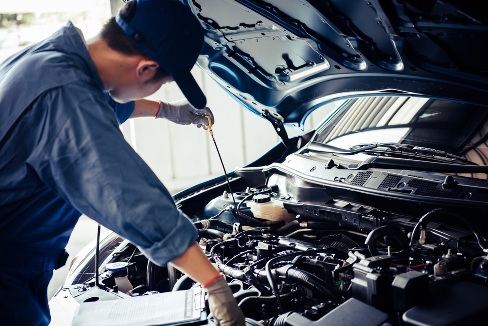 Car,mechanic,holding,checking,gear,oil,to,maintenance,vehicle,by